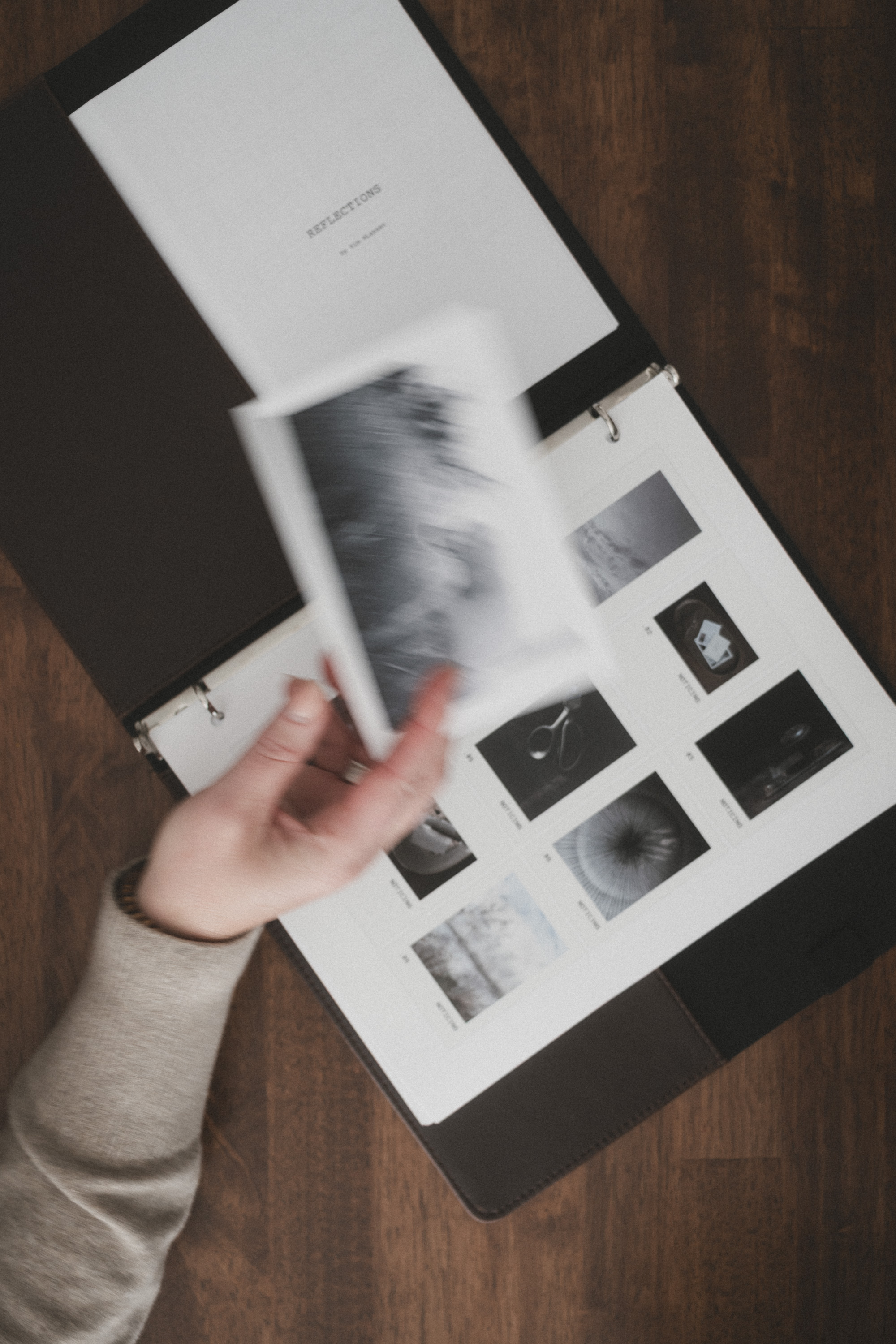 Printed photographs and a handmade photo book on a wooden table